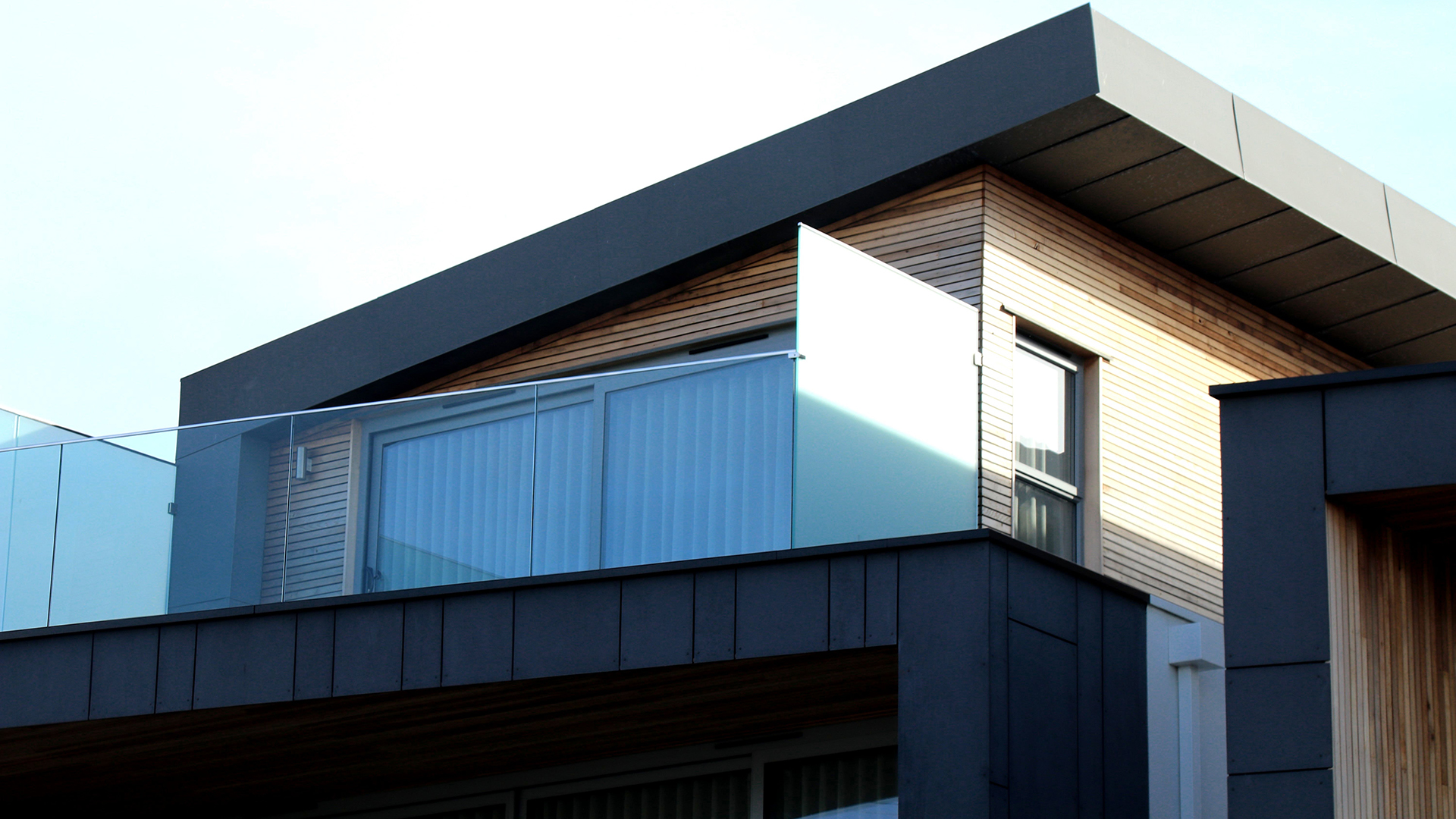 Exterior of a modern wood and glass office building on a blue sky