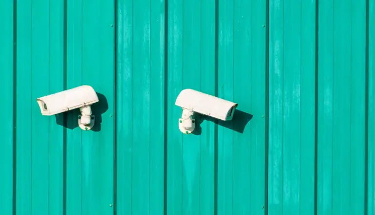 White security cameras on paneled wall.