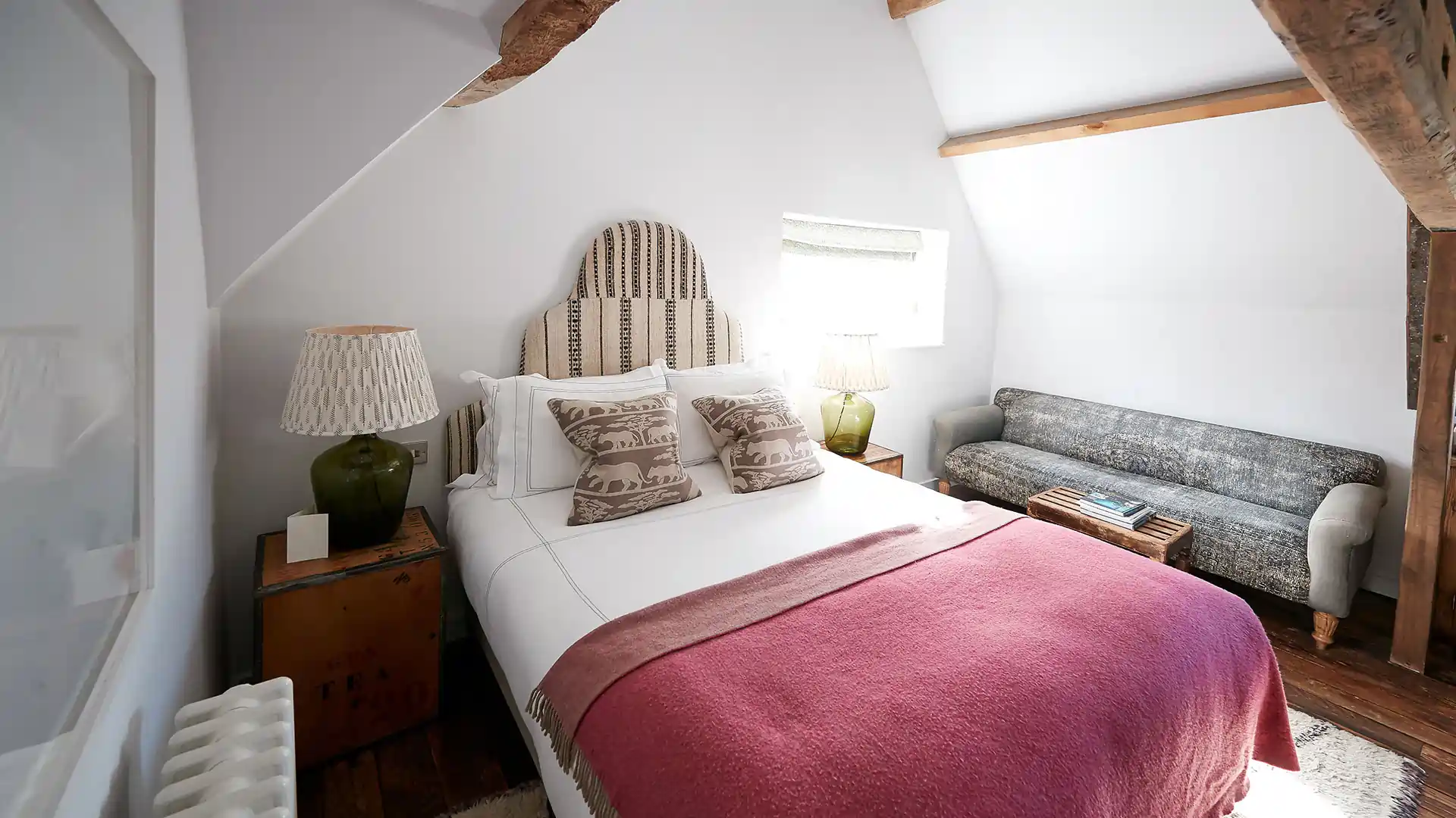 Bedroom with pink throw blanket on bed in airbnb rental house