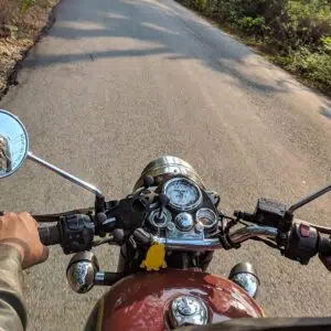 motorcycle driving down a forest road