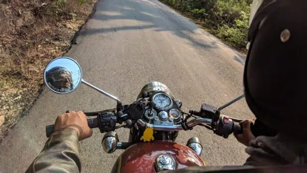 motorcycle driving down a forest road