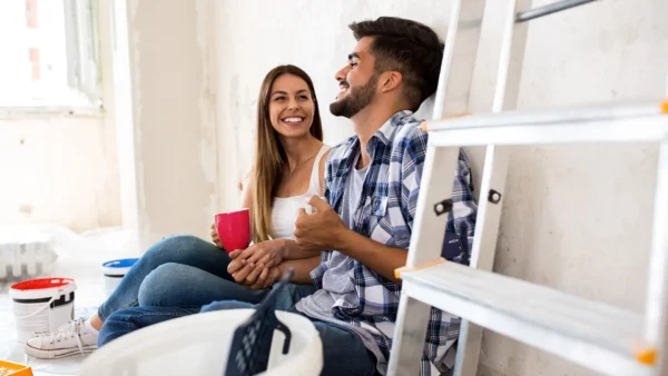 couple sitting laughing while doing home renos