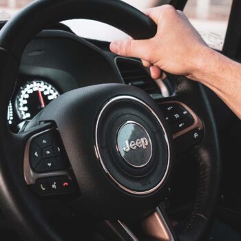 Hand holding jeep steering wheel