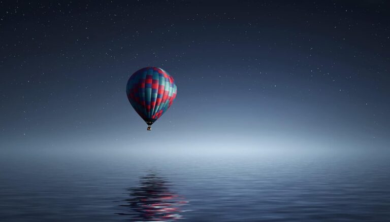 Hot air balloon flying over the water.