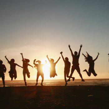 happy team jumping in the sunset