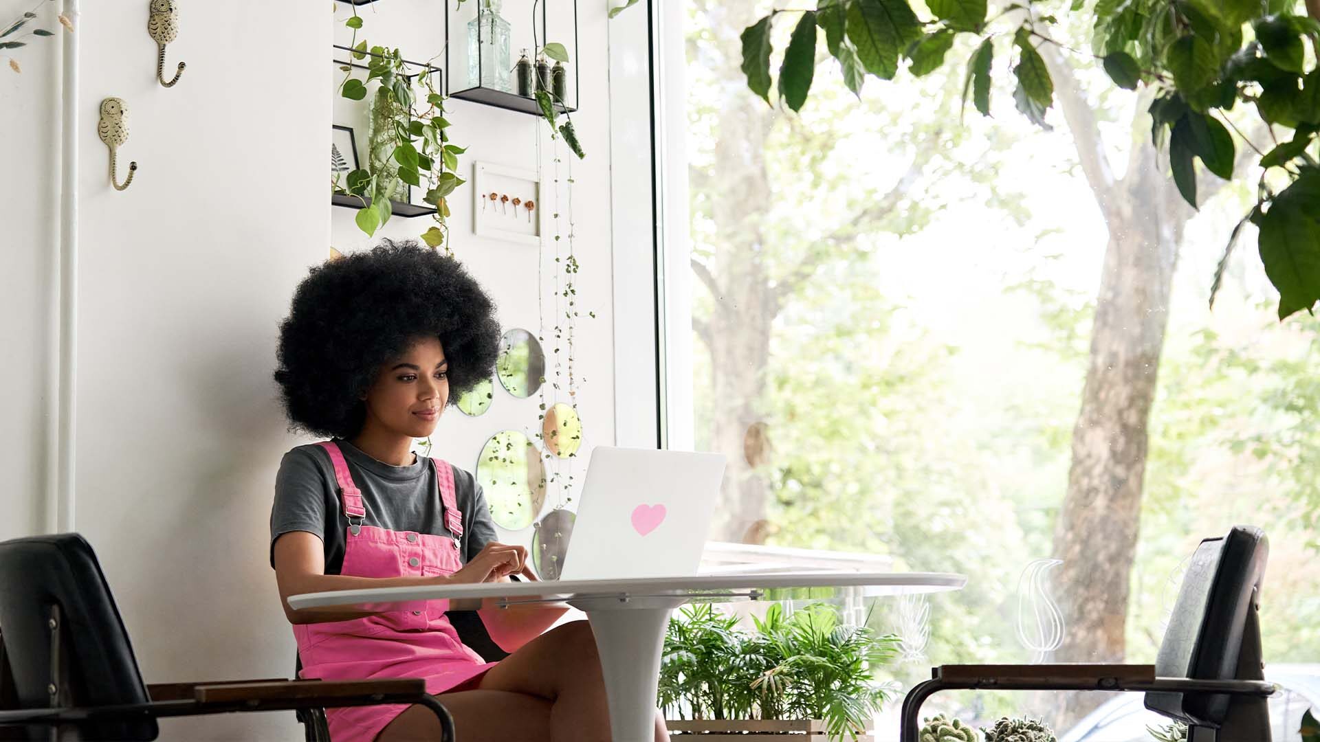 Person working on a laptop at home in a bright and airy room.