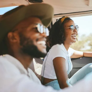 driver and passenger smiling in car