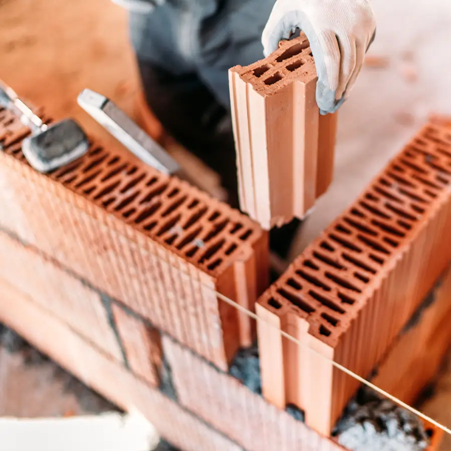 Bricklayer constructing industrial building.