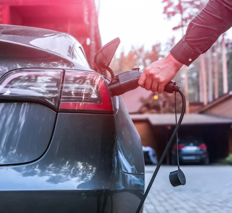 Electric car with person holding charging cable handle