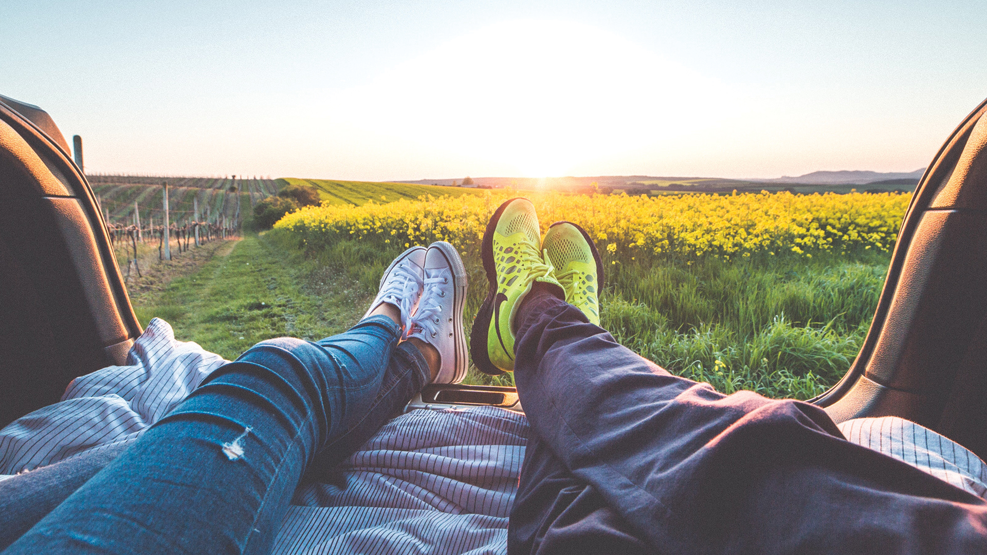 people looking at yellow field with feet up