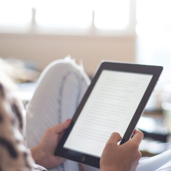 woman sitting on chair using black ipad