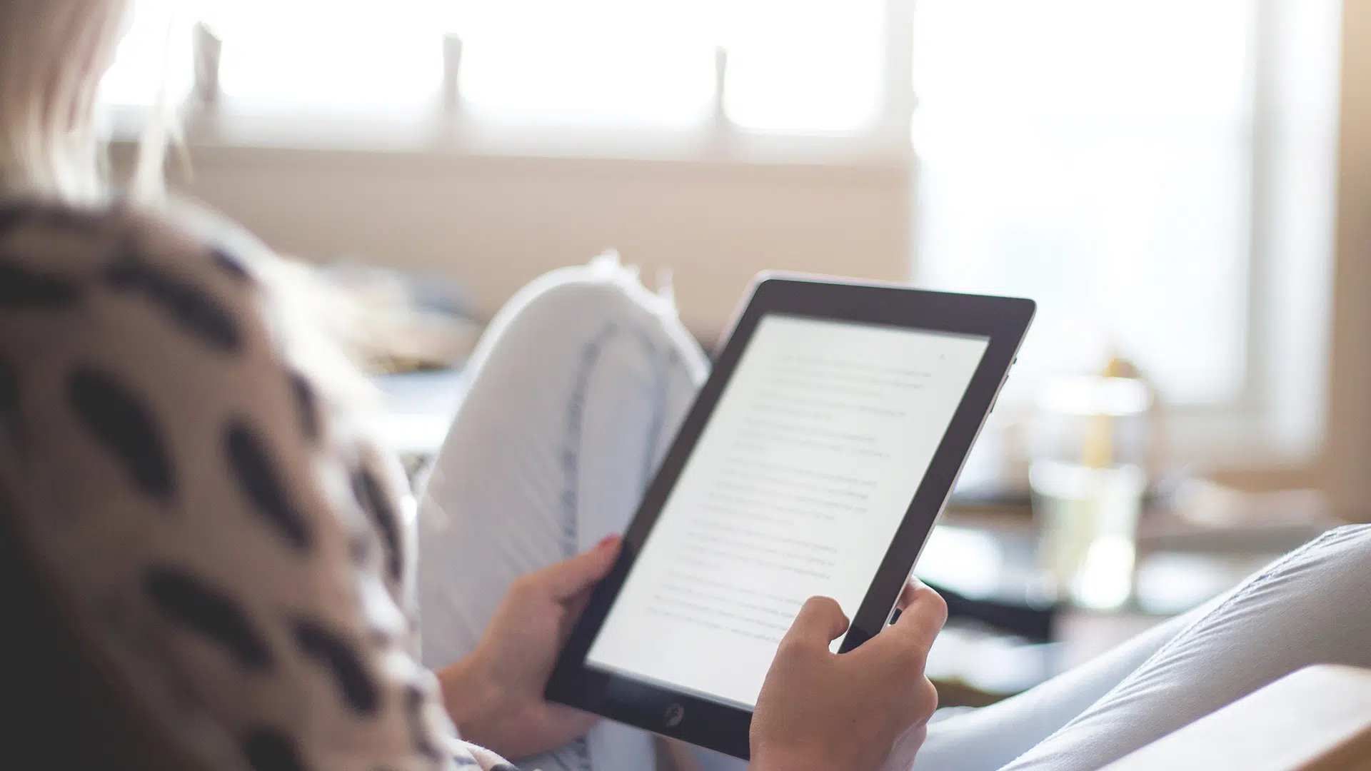 woman sitting on chair using black ipad