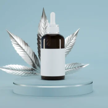 tincture bottle on glass riser with silver cannabis leaf behind