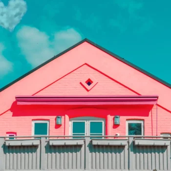 pink house with blue sky and clouds