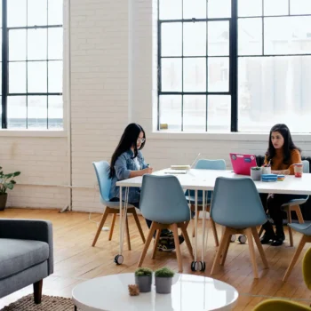 Two people working at a desk in an office.