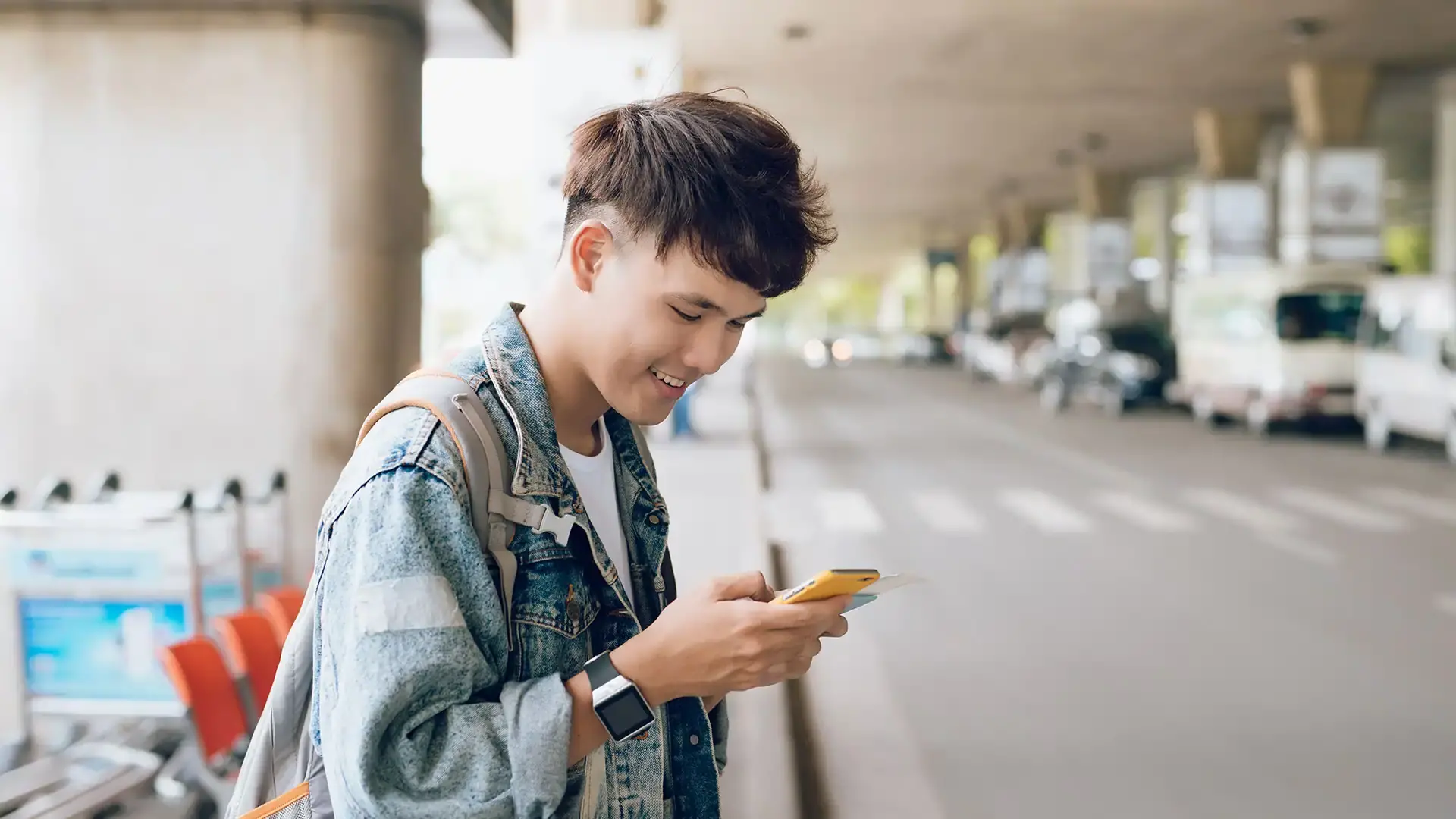 Person at airport ordering rideshare from their smartphone.