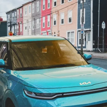 blue car parked on road in front of row houses