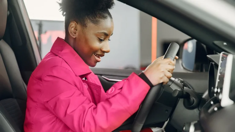 young female behind steering wheel of vehicle