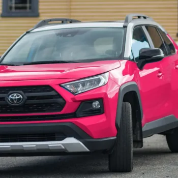 toyota suv in front of yellow house