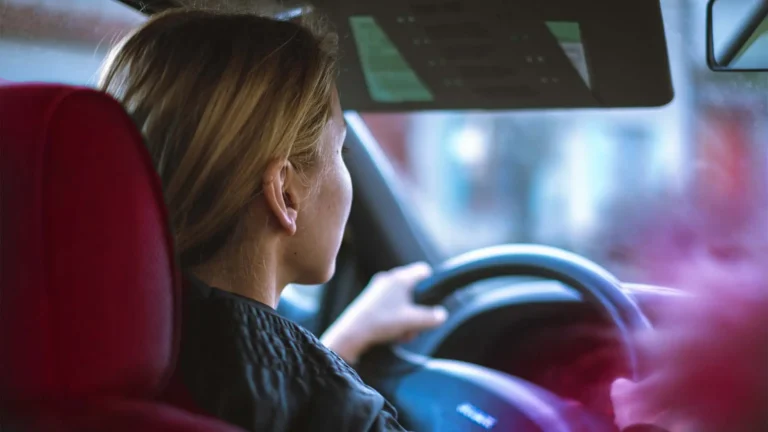 young driver behind steering wheel of car