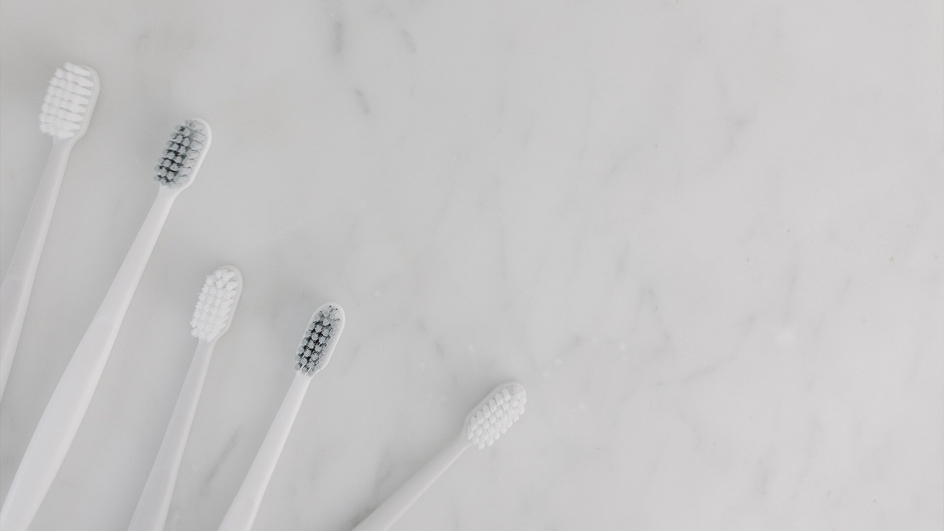 Toothbrushes on marble counter.