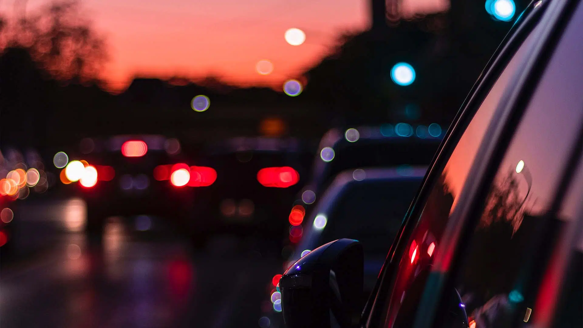 Busy street with cars driving by at dusk.