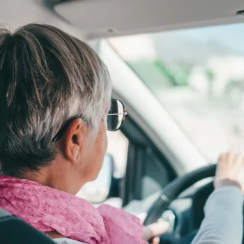 Older person driving a car.