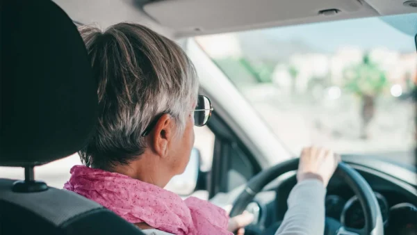 Older person driving a car.