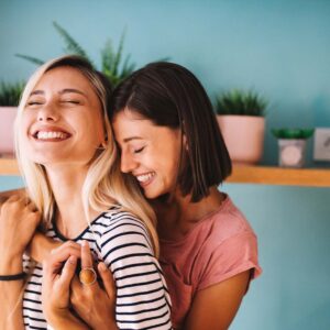 A young couple hugging and smiling in their home.