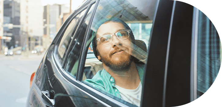 Man looking out an Uber or Lyft window.