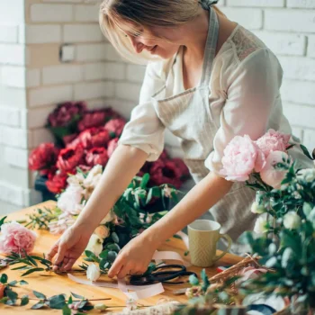 Florist arranging a bouquet of peonies.