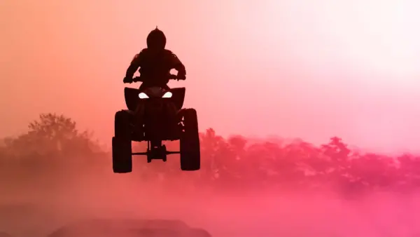 Quad bike jumping in the sunset.