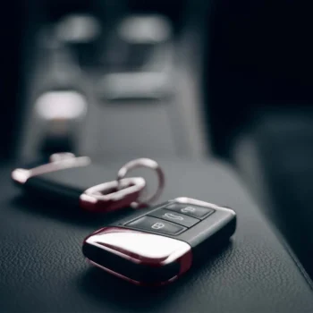 Car keys on the armrest of a rental car.